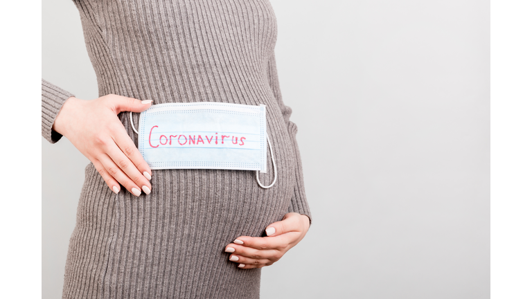 medical mask on the belly of a pregnant girl. hild protection. Concept of coronavirus, covid-19, quarantine
