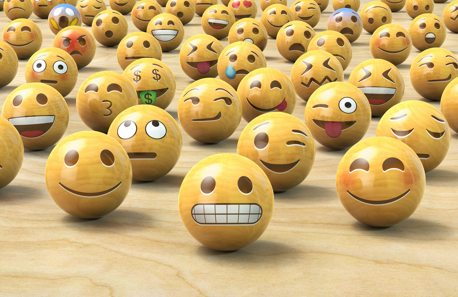 Many wooden emoticon or Emoji face balls, one up front