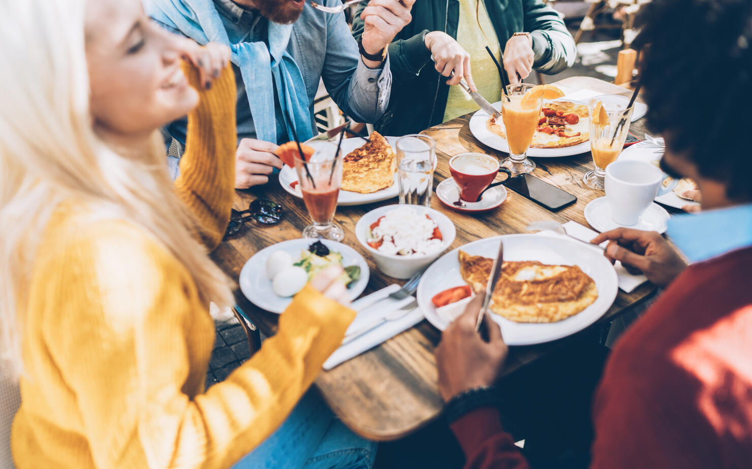 Multi ethnic group of friends eating lunch in a restaurant