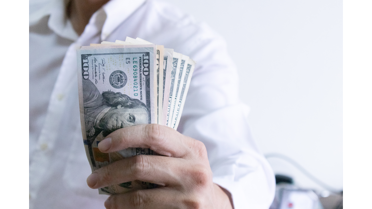 Man holding dollar banknote.young businessman holding money.Business and finances making and saving money concept.