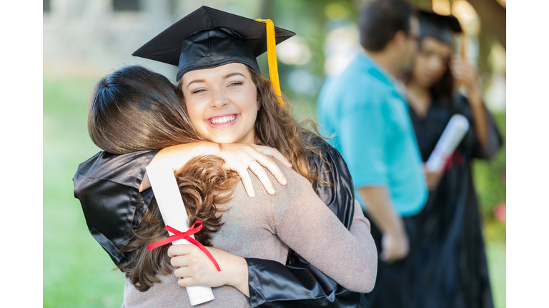 Happy college grad hugs her mom