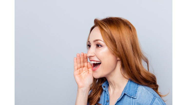 Close up side profile photo beautiful she her curly lady spread news novelty chatterbox hold arm hand near mouth help tell speak louder wear casual blue jeans denim shirt isolated grey background