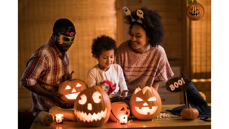 Happy African American family enjoying in Halloween at home.