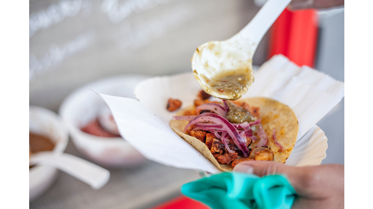 Close-Up Of Hand Holding Taco In Paper Plate