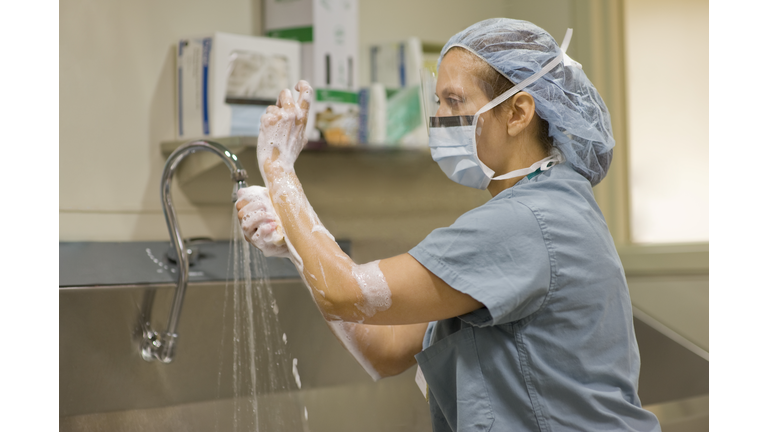 Surgical nurse scrubs her hands