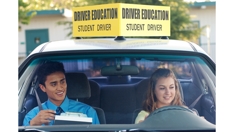 A student driver with her driving instructor