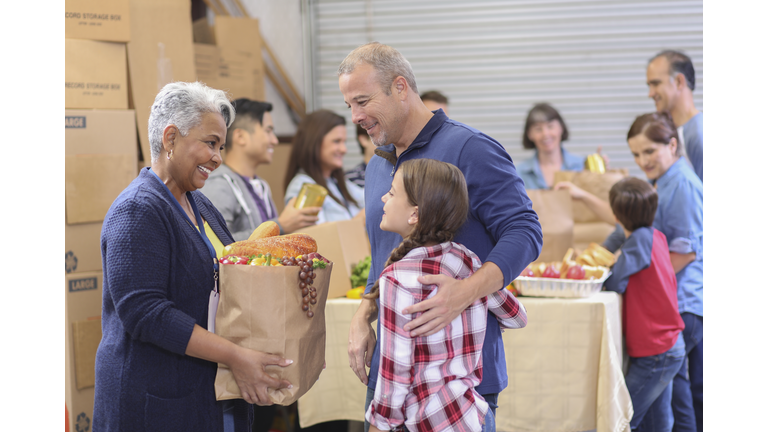 Multi-ethnic group of volunteers work at food bank.