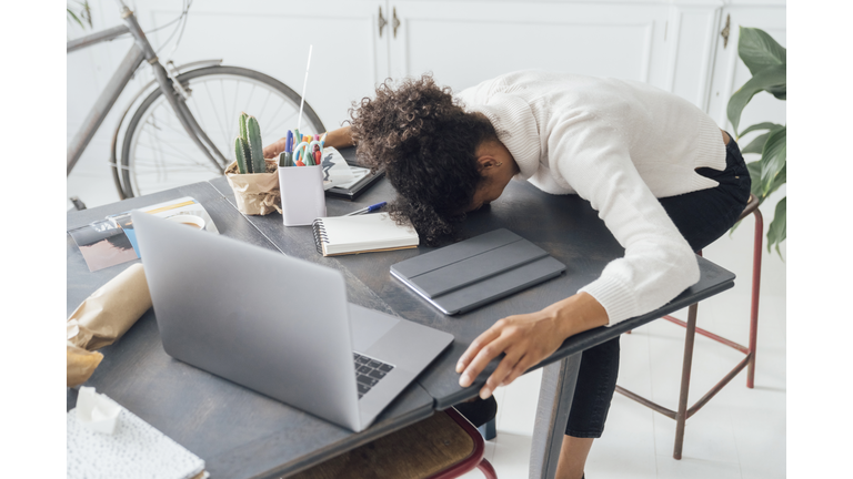 Tired freelancer sleeping on her deak