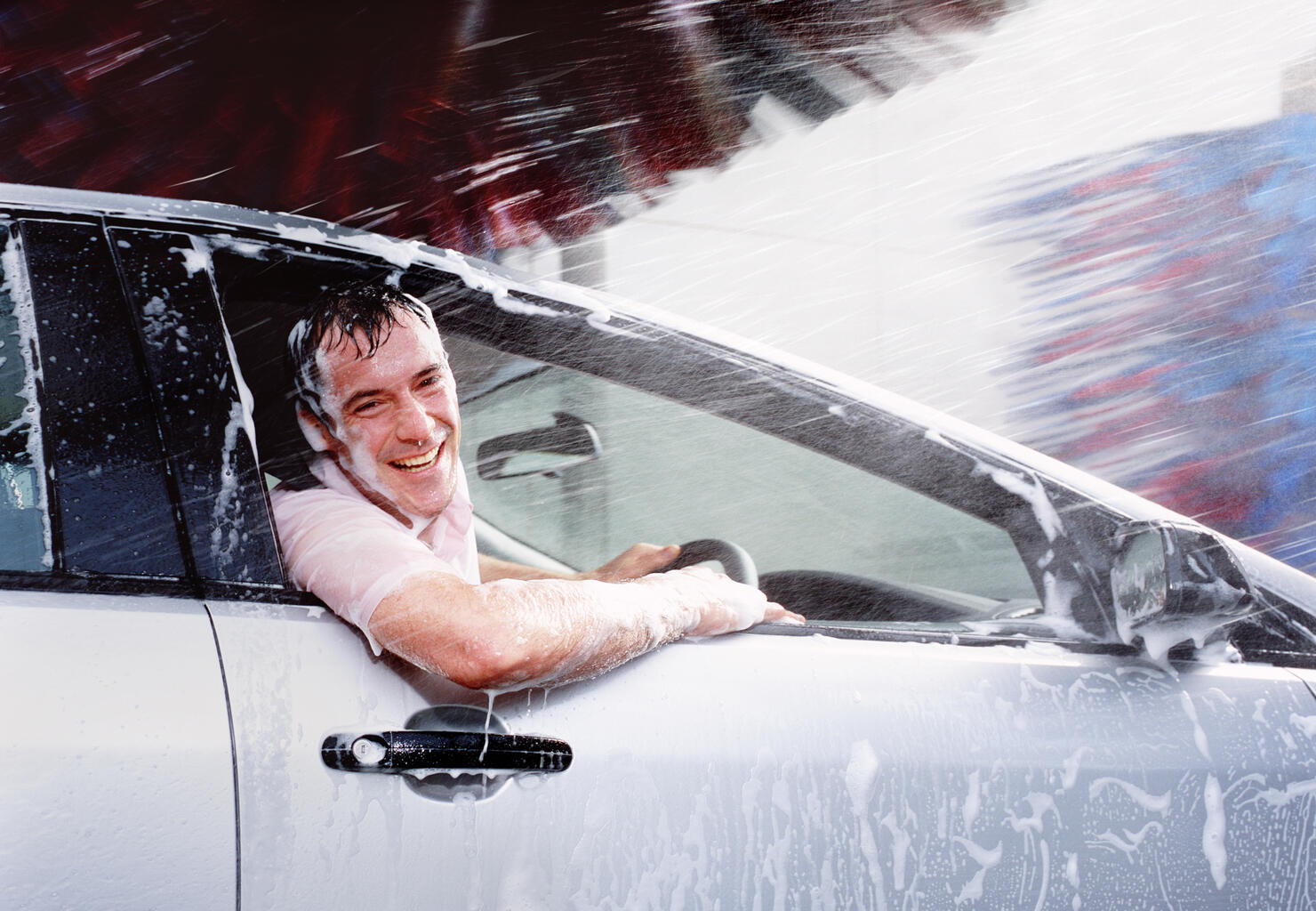 Man caught out in car wash with window open.