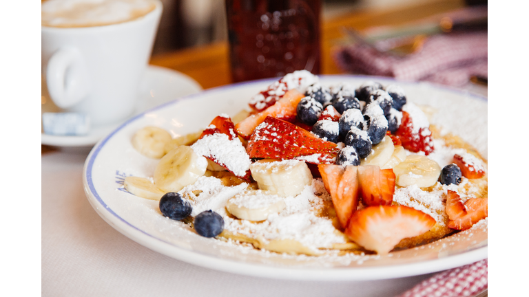 Traditional American breakfast - pancakes with fresh banana, blueberry and strawberry