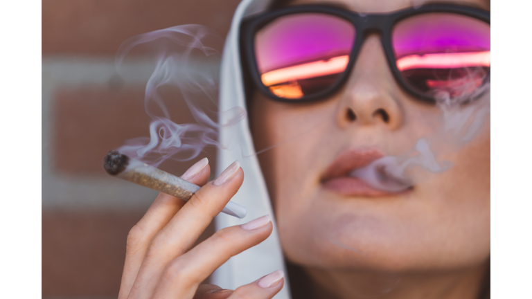 Young woman smoking marijuana joint