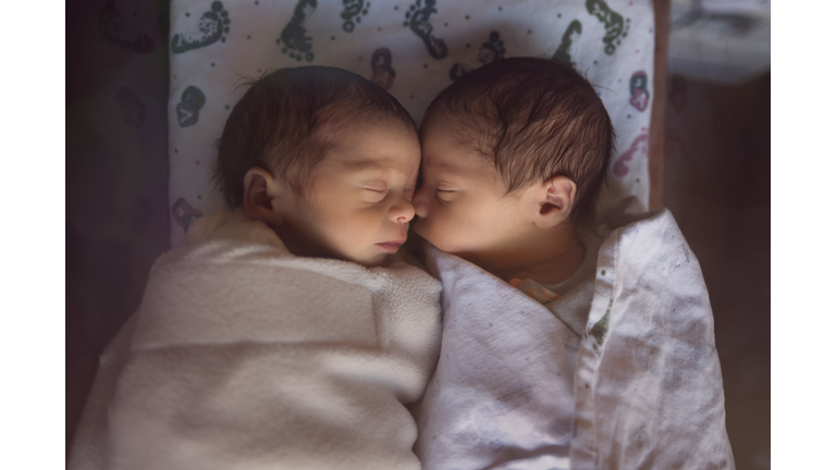 Premature Newborn Fraternal Twins in Hospital Sleep Together in Plastic Crib