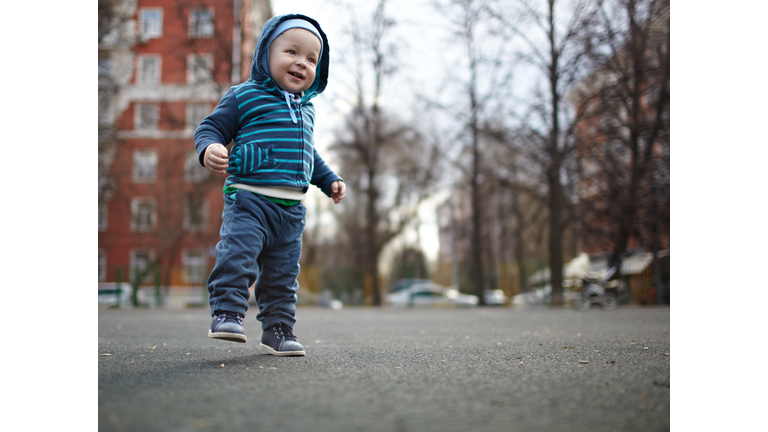 Smiling Baby Boy Walking On Street