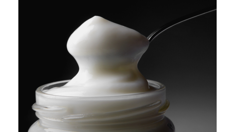 Close-up of a spoon in a jar full of mayonnaise