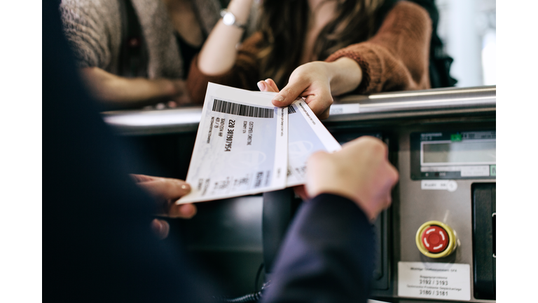 Travellers Getting Boarding Passes At Check-In