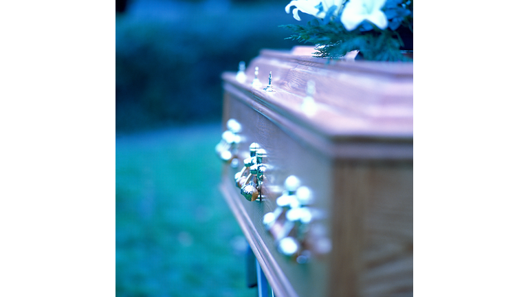 close-up of the side of a coffin with brass handles