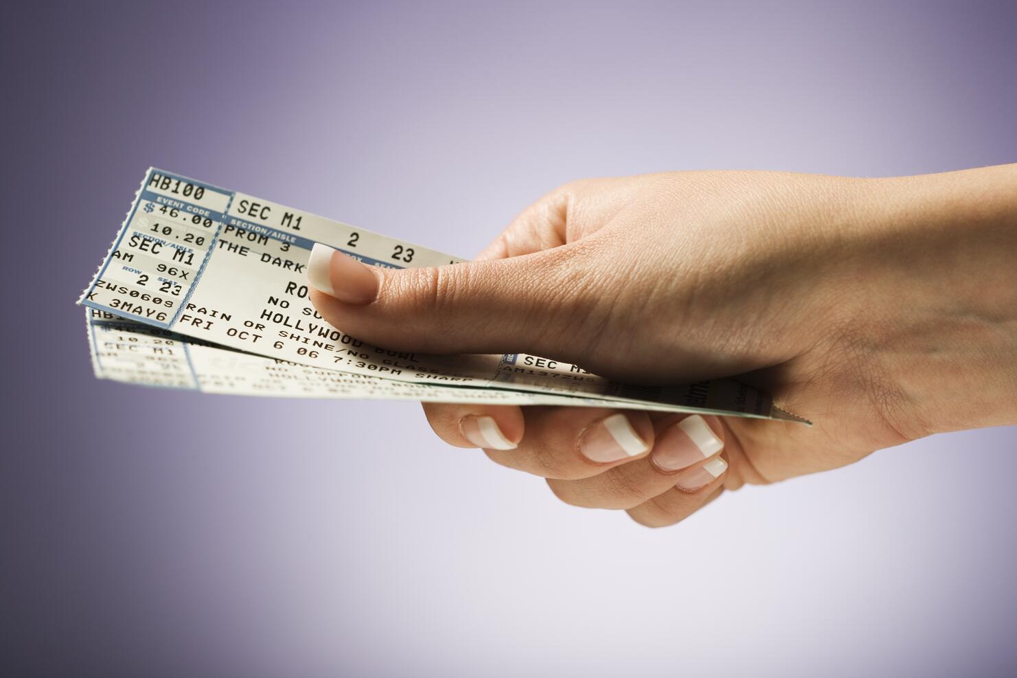 Woman holding concert tickets