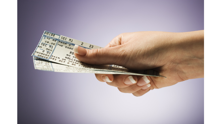 Woman holding concert tickets