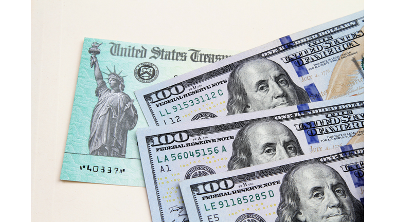 Tax refund check from US Treasury and US currency 100 dollar bills