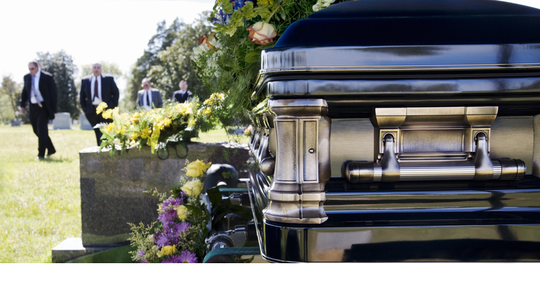 Funeral procession in cemetery.