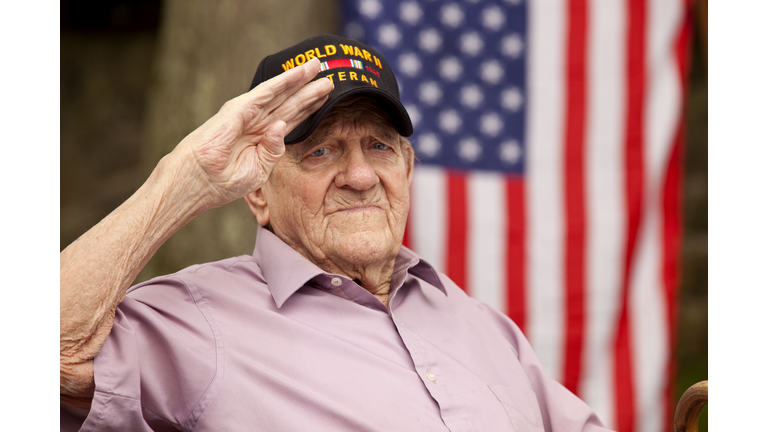 World War Two, Veteran wearing cap with text, "World War Two Veteran". Saluting
