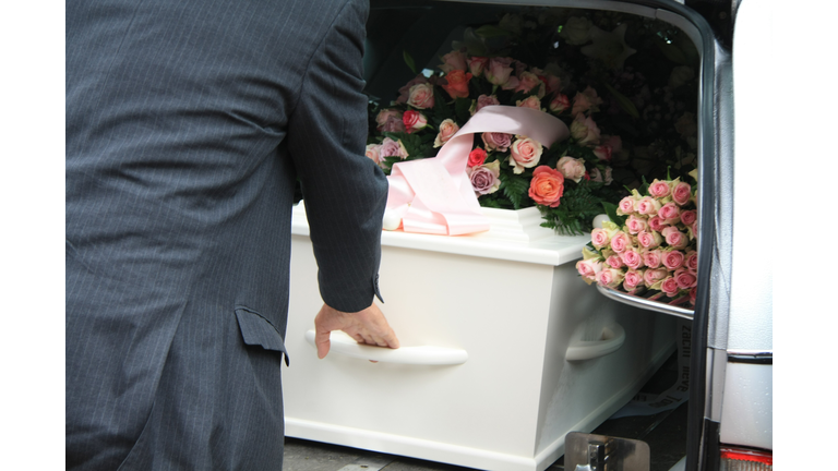 White coffin in a grey hearse