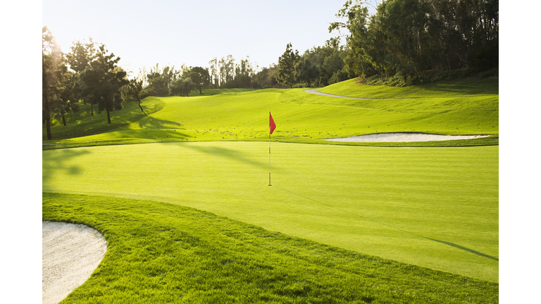 Flag on golf course surrounded by sand traps