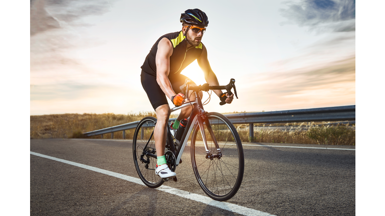 Handsome young man cycling on the road.