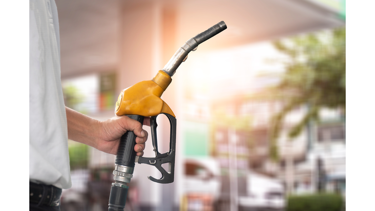 Pumping equipment gas at gas station. Close up of a hand holding fuel nozzle