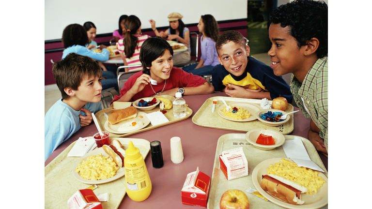 Group of kids (12-14) having lunch in cafeteria