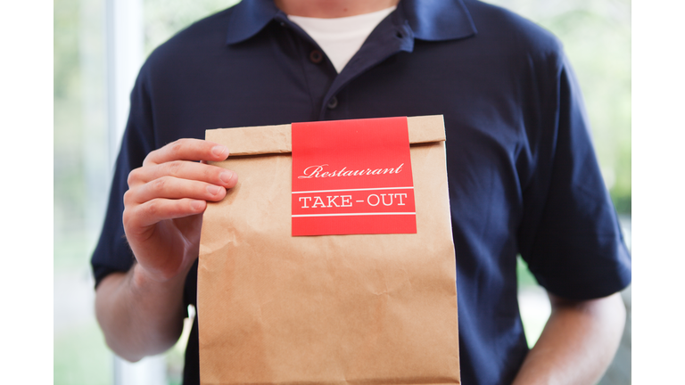 Take Out Food Delivery Person Holding Bag of Restaurant Dinner