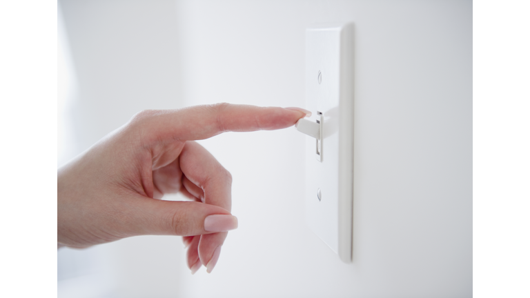 Korean woman turning off light switch