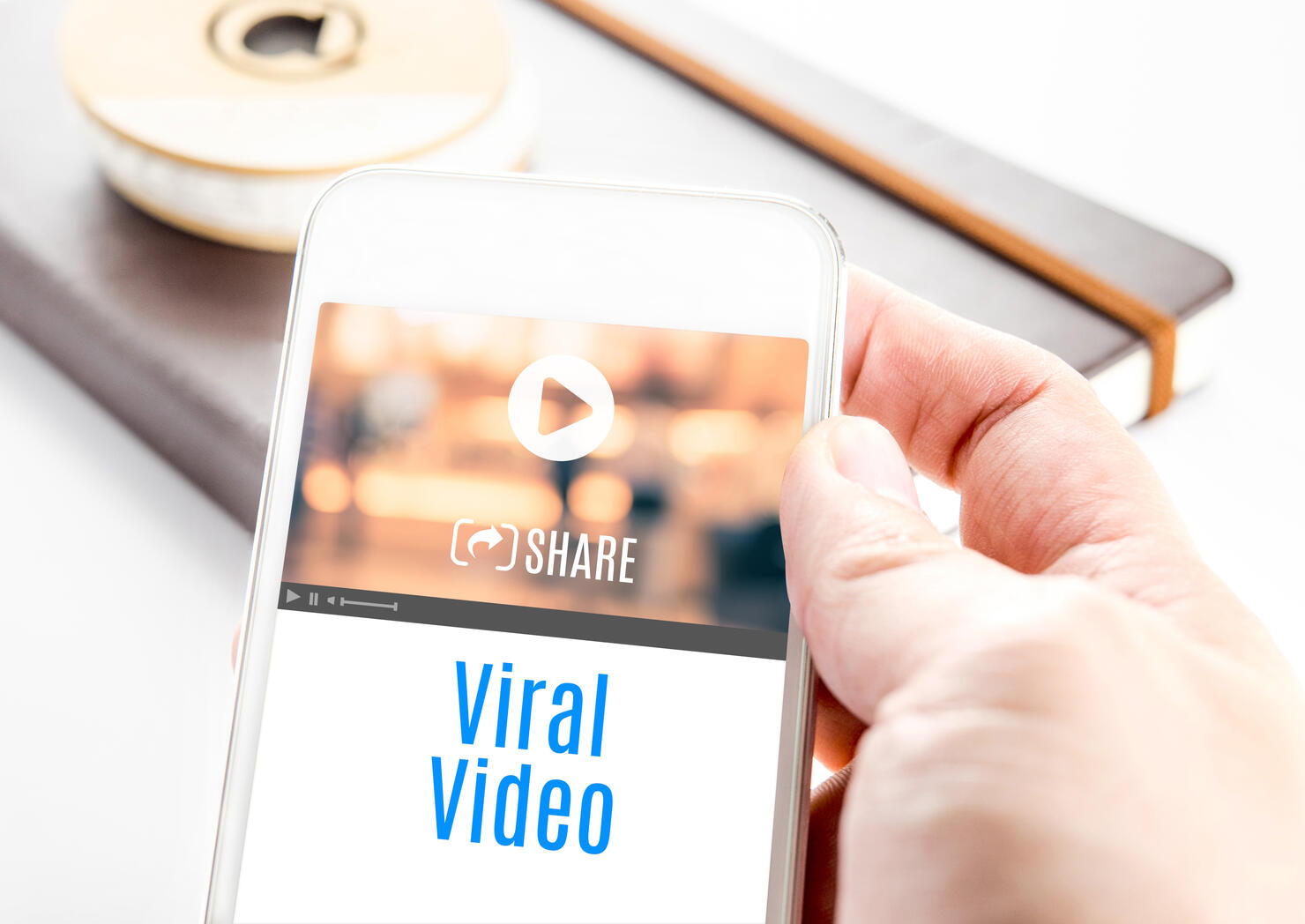 Close up hand holding smart phone with Viral Video word