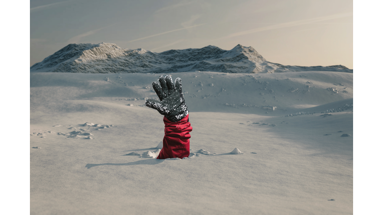 Hiker stretching out his snow covered hand to signal help because of snow avalanche . Danger extreme concept