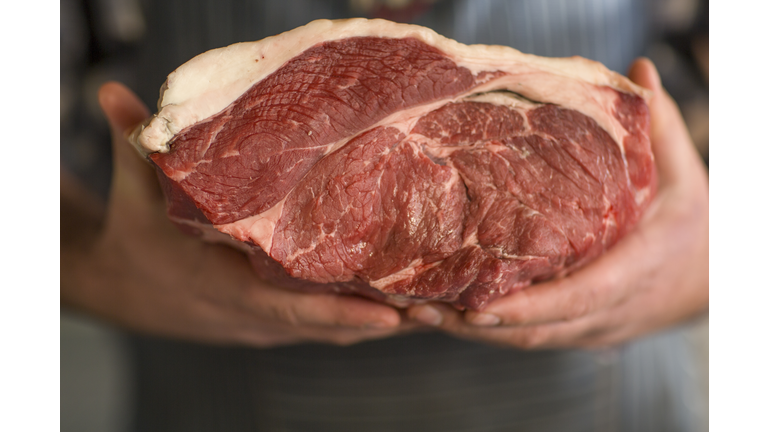 Butcher holding piece of raw meat