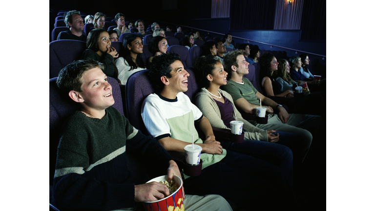 Multi-ethnic group of teens (17-19) watching movie in theater