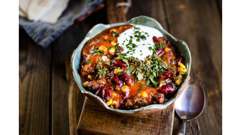 Chili con carne with kidney beans and corn, sour cream, parsley, tortilla bread