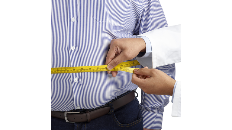Doctor measuring man's waist