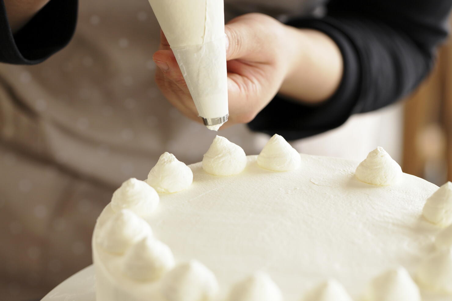 Woman decorating whipped cream on cake