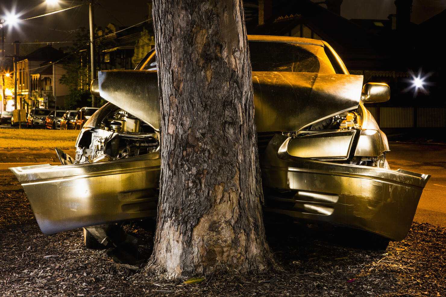 Car crashed on tree trunk at night