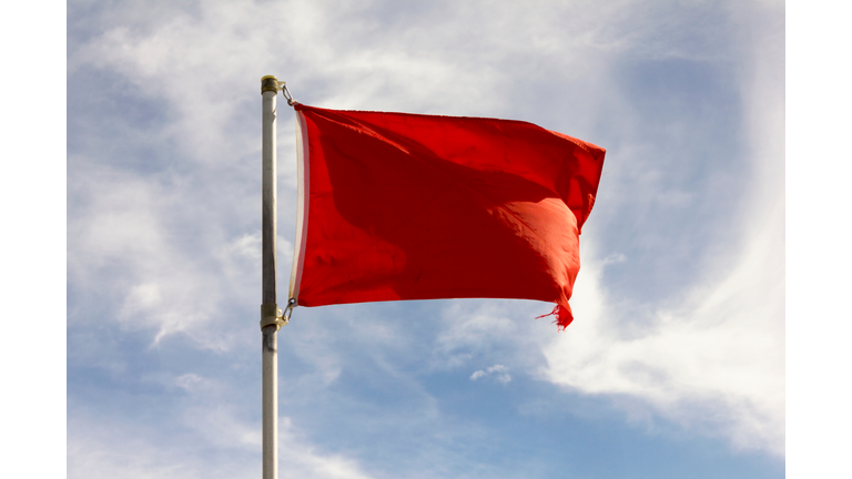 Low Angle View Of Red Flag Against Sky