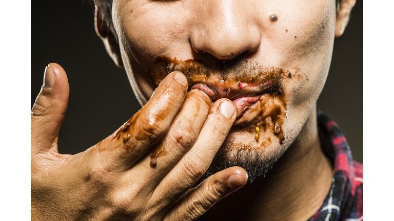 Mid adult man licking chocolate,close up shot