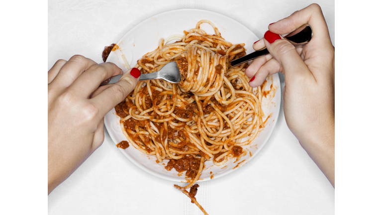 Female eating spaghetti, overhead view