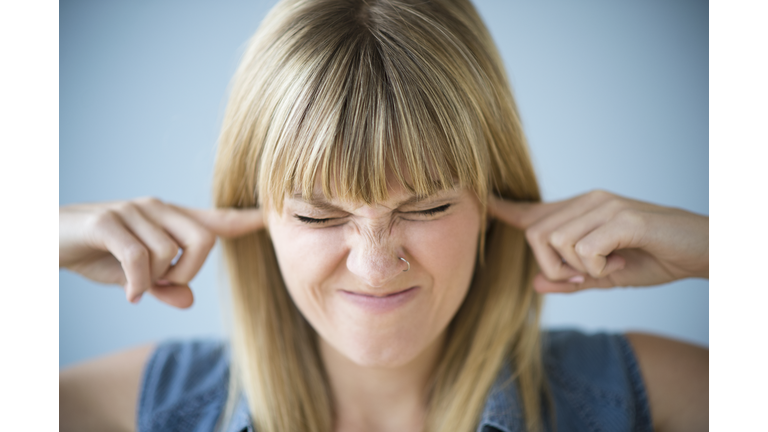 Woman blocking ears with fingers