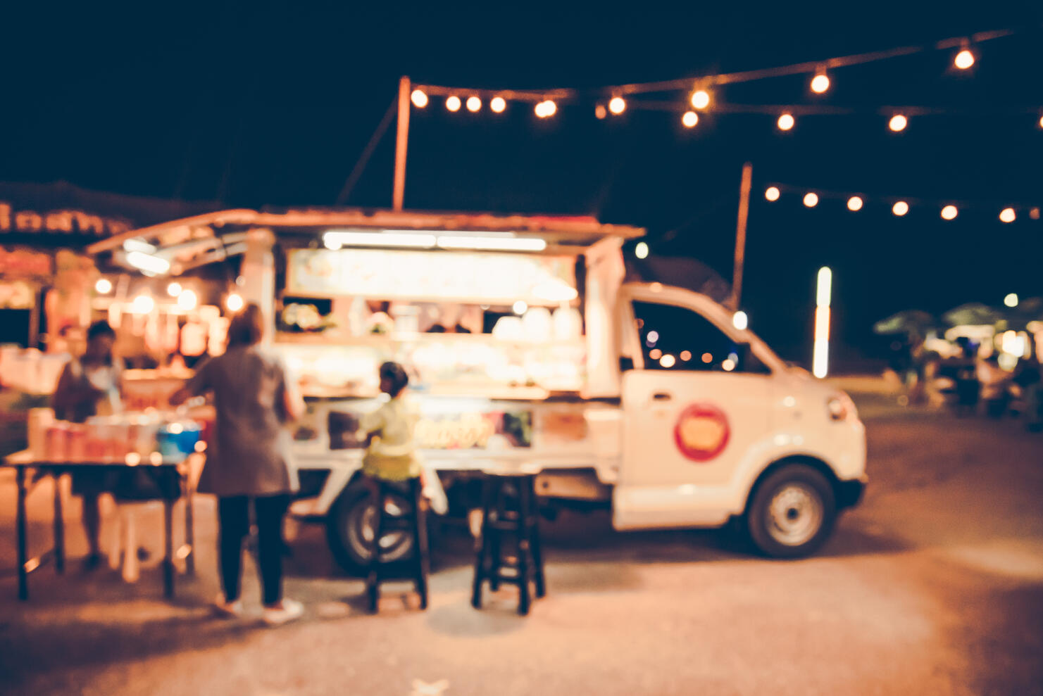 Defocused Image Of People By Food Truck At Night