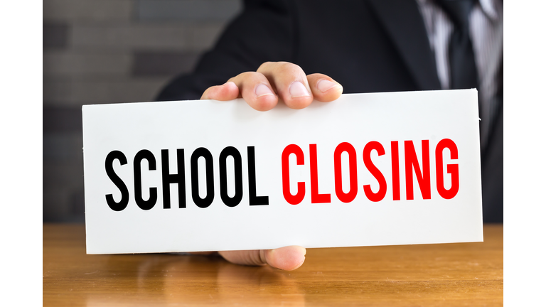 School closing, message on white card and hold by businessman