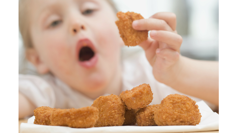 Little girl eating chicken nuggets