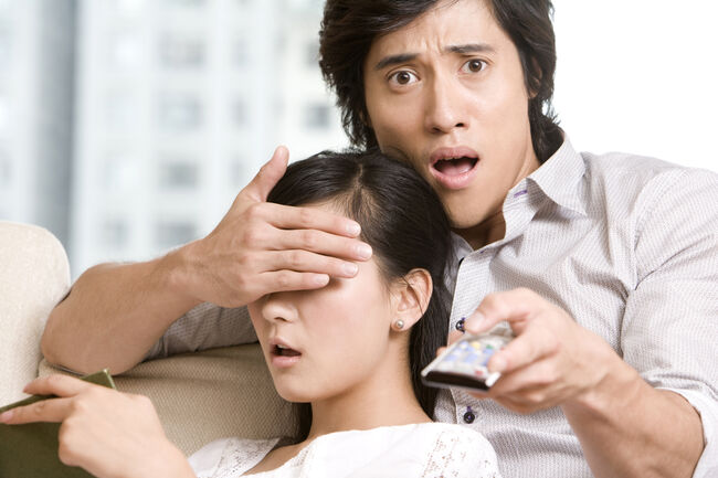 Asian couple cuddling on a sofa