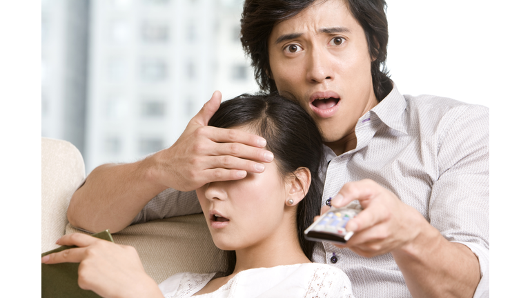 Asian couple cuddling on a sofa