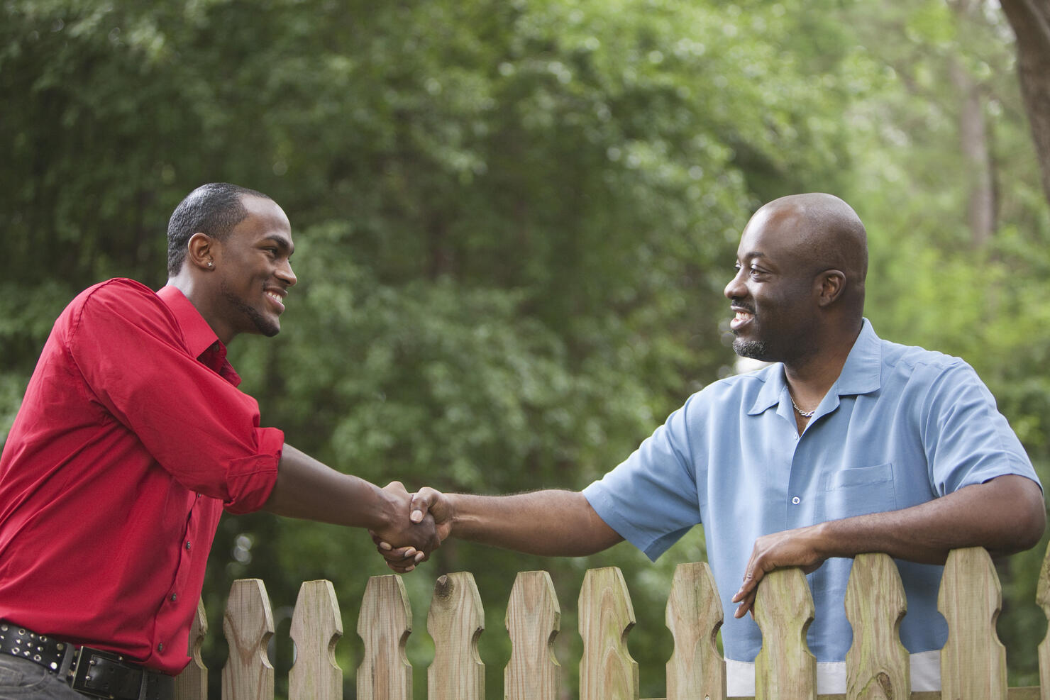 African American neighbors greeting each other over fence